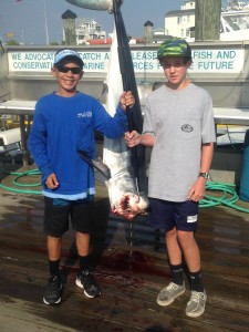 two boys standing next to a hanging mako