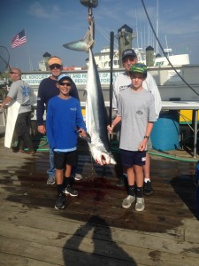 two boys with mako shark on dock